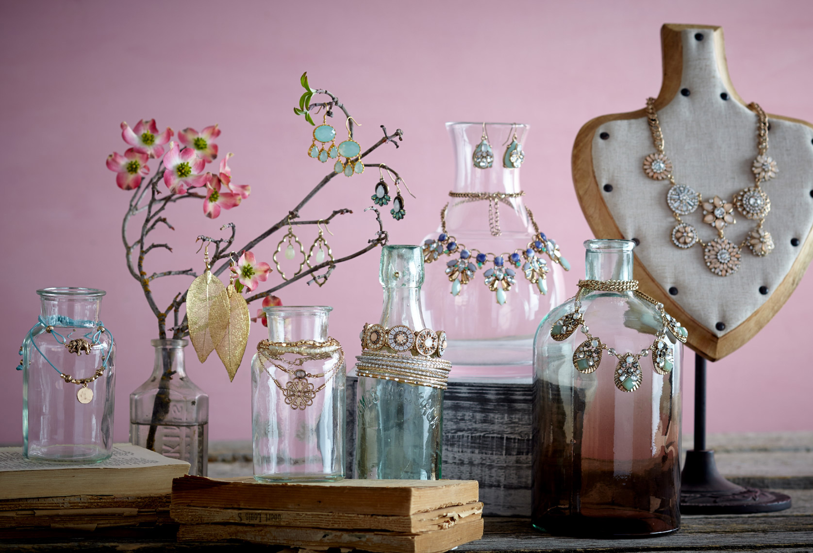 teal and peach jewelry hanging on vases with flowers and pink background San Francisco product photographer