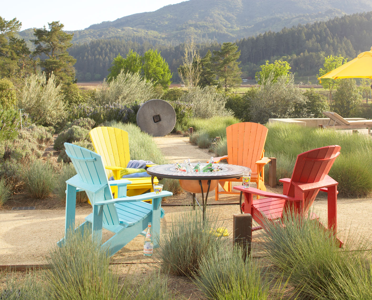 Collection Of Colorful Adirondack Chairs Around Fire Bowl In Wine