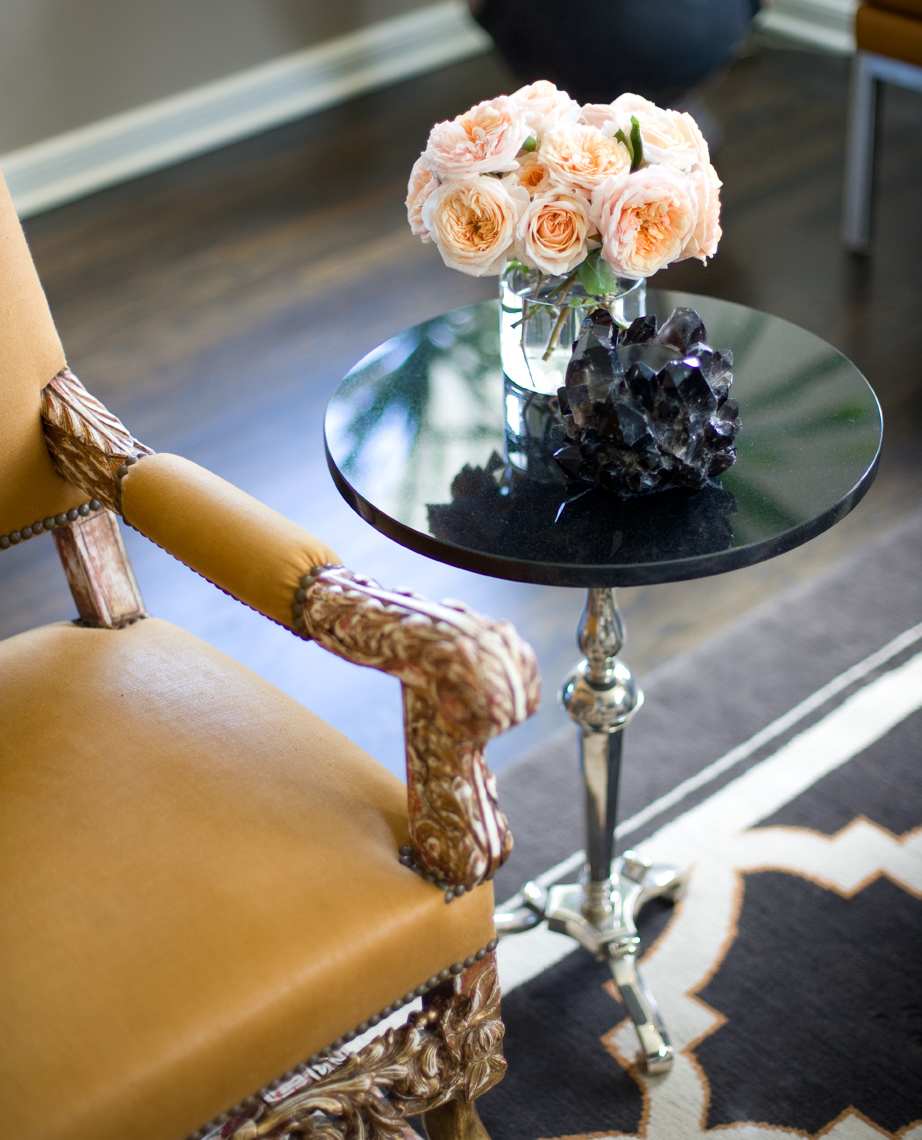 detail of yellow armchair and small table with peach colored blooming flowers San Francisco interior photographer
