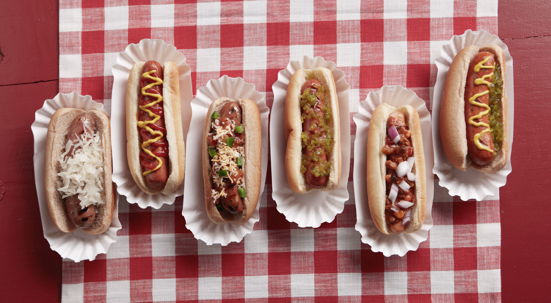 array of hotdogs with different toppings on red plaid tablecloth San Francisco food photographer