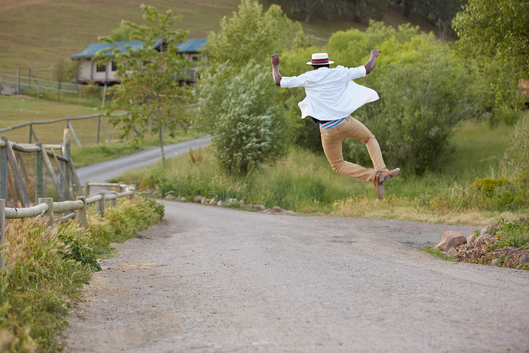Man in white shirt jumps and clicks his heals together on a country road San Francisco lifestyle photographer