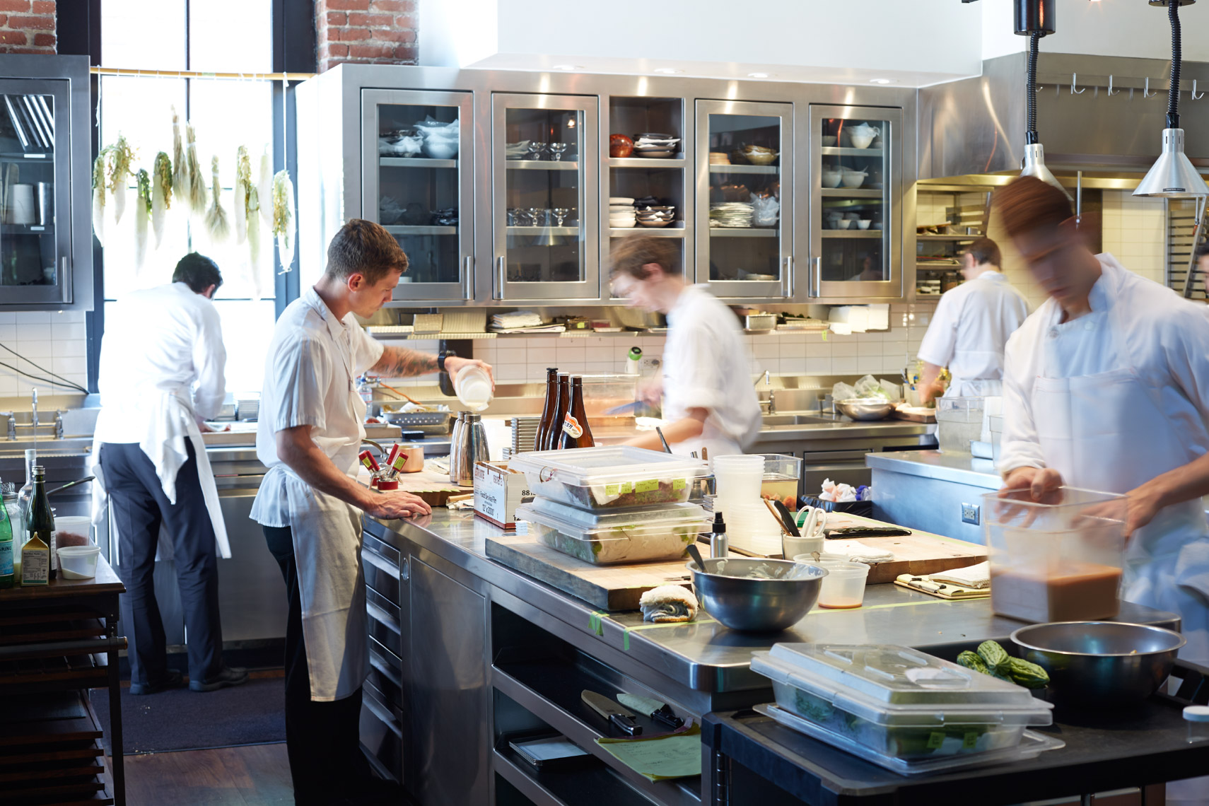 Chefs in kitchen preparing food as seen through glass entry San Francisco lifestyle photographer