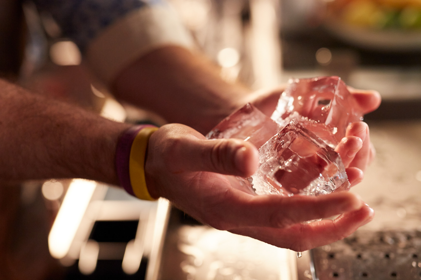  man holding large hand-cut clear ice cubes San Francisco food photographer