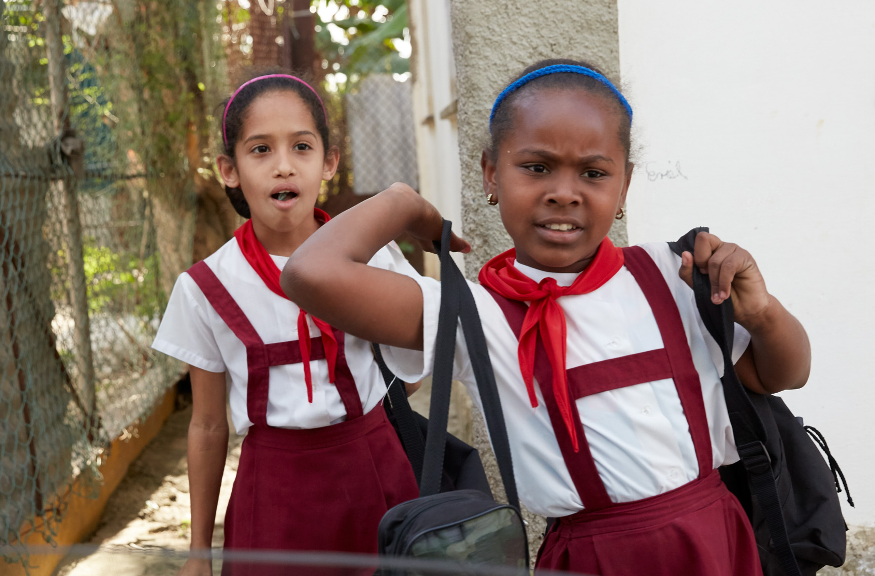 2 young girls in uniforms in Cuba walking to school