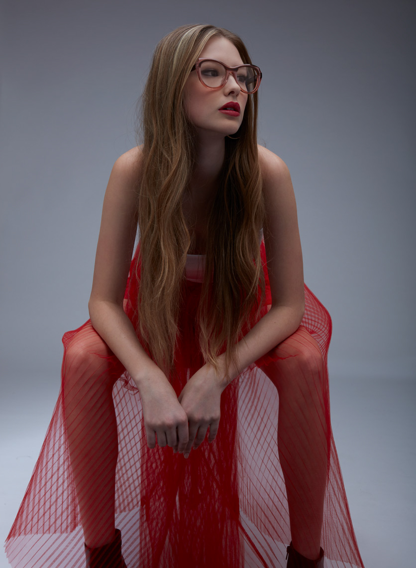 woman sitting in red mesh skirt wearing red frames San Francisco fashion photographer