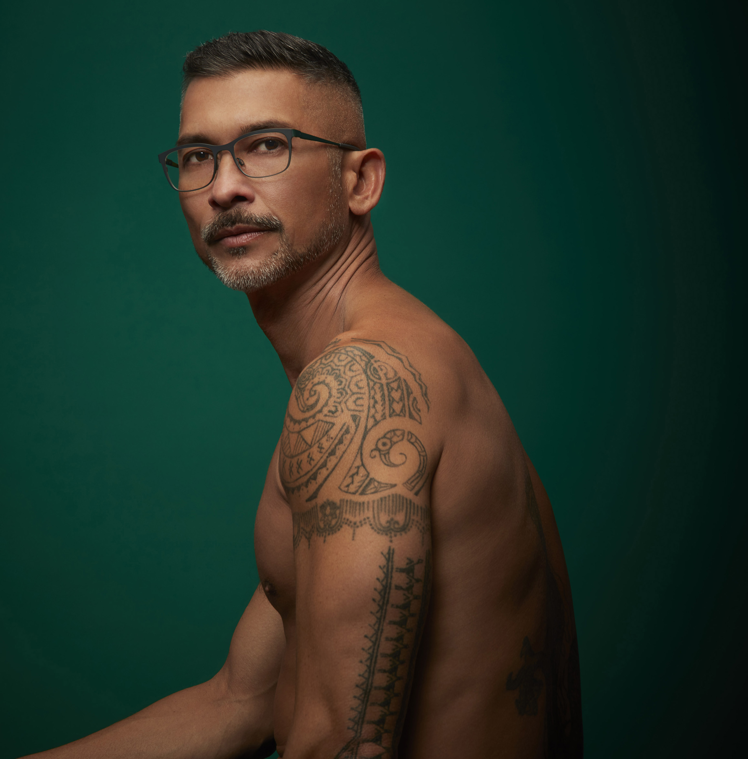 Man with tattoos wearing glasses and no shirt San Francisco fashion photographer