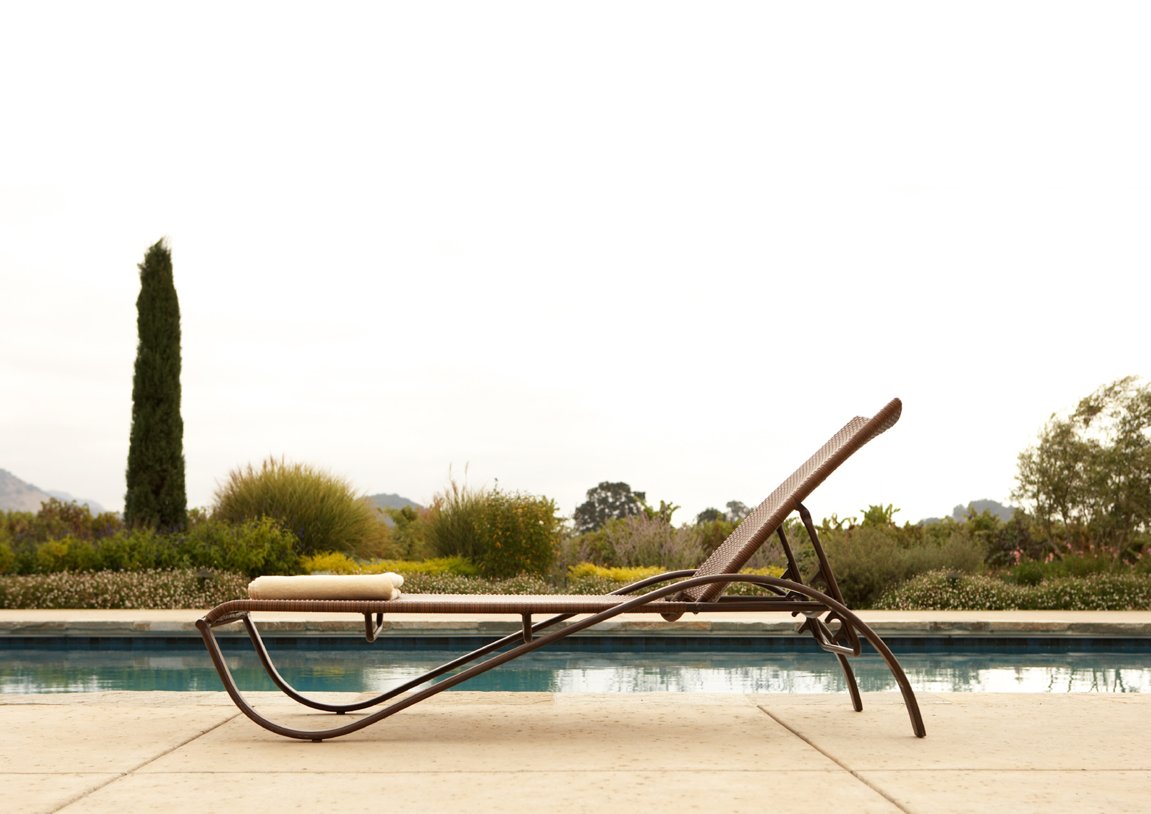 poolside sleek brown metal chaise with towel and garden scene San Francisco architectural photographer