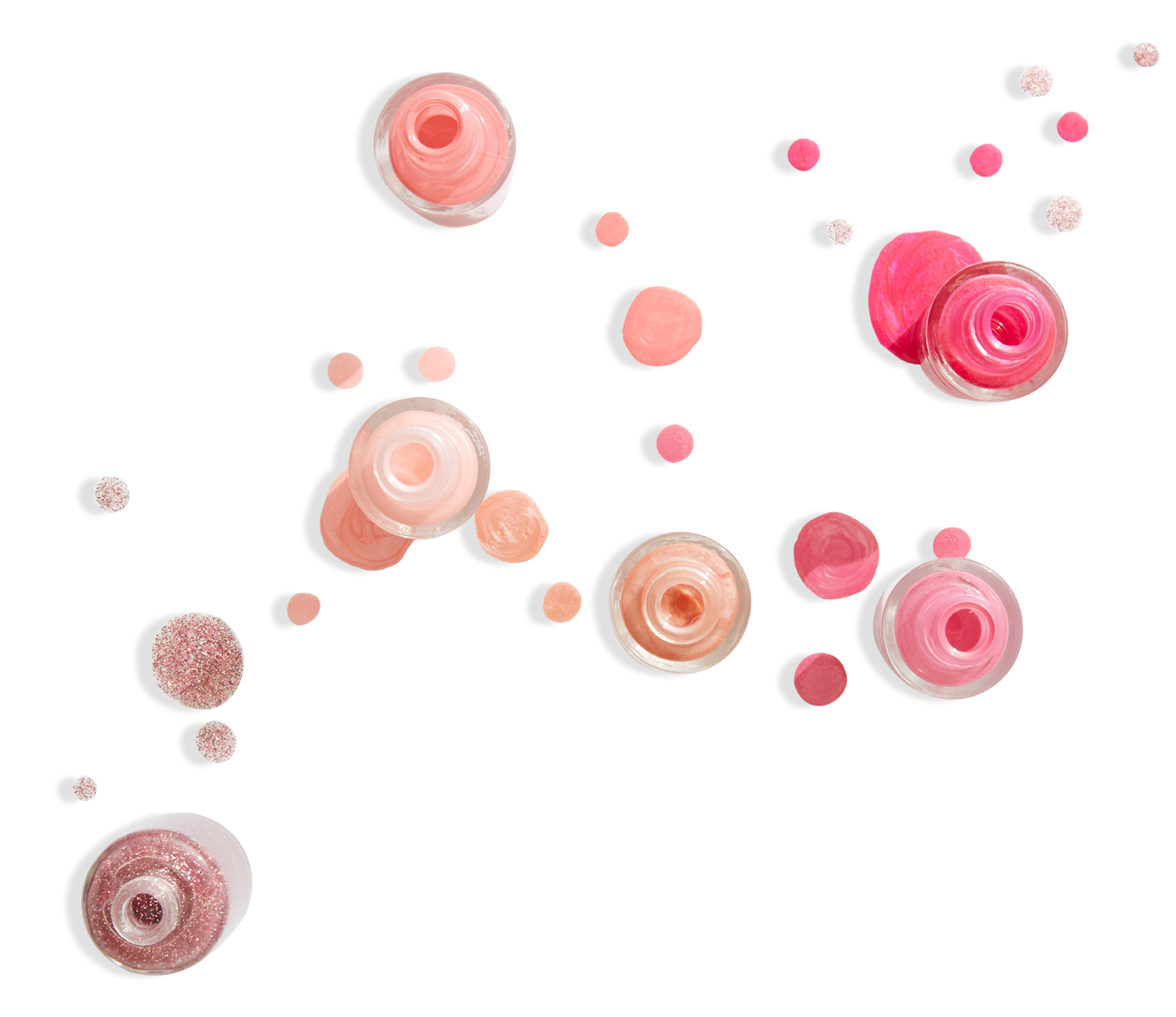 variety of pink nail polishes and droplets on white surface San Francisco product photographer