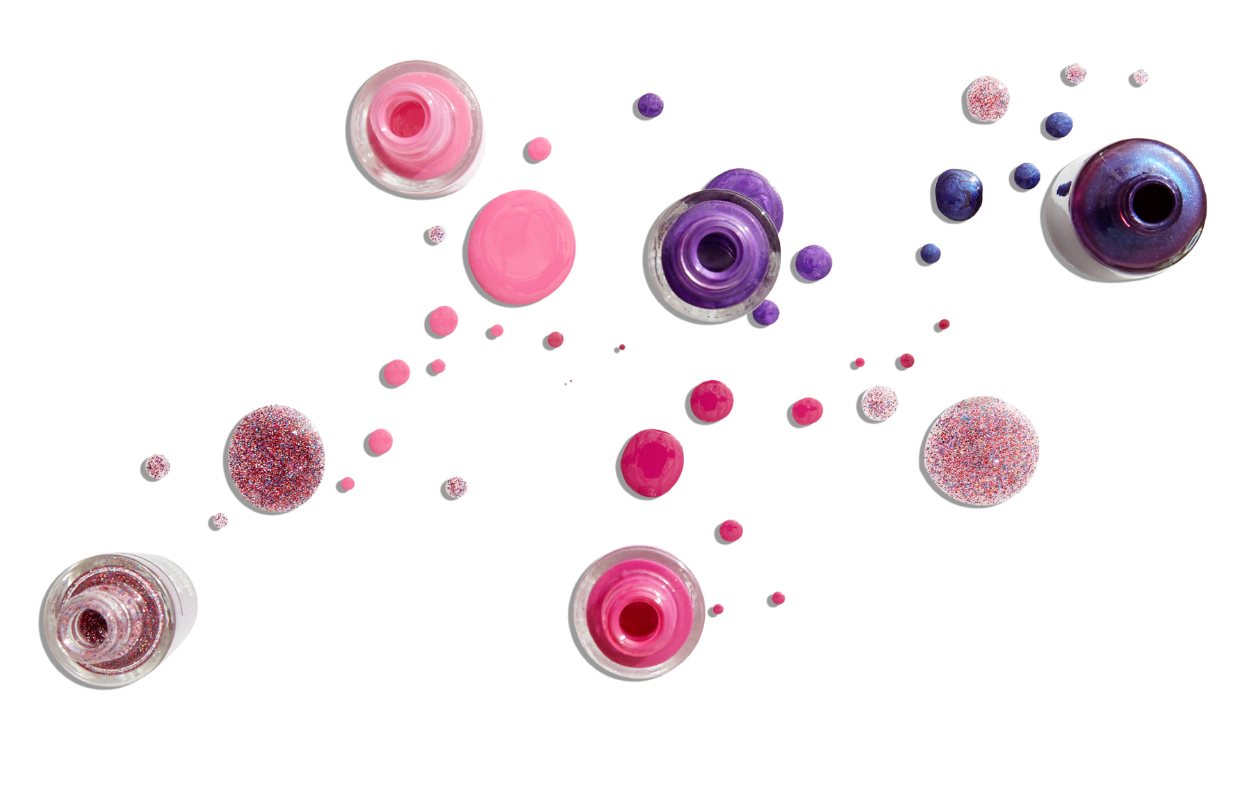 different colored bottles of nail polish with droplets on white surface San Francisco product photographer