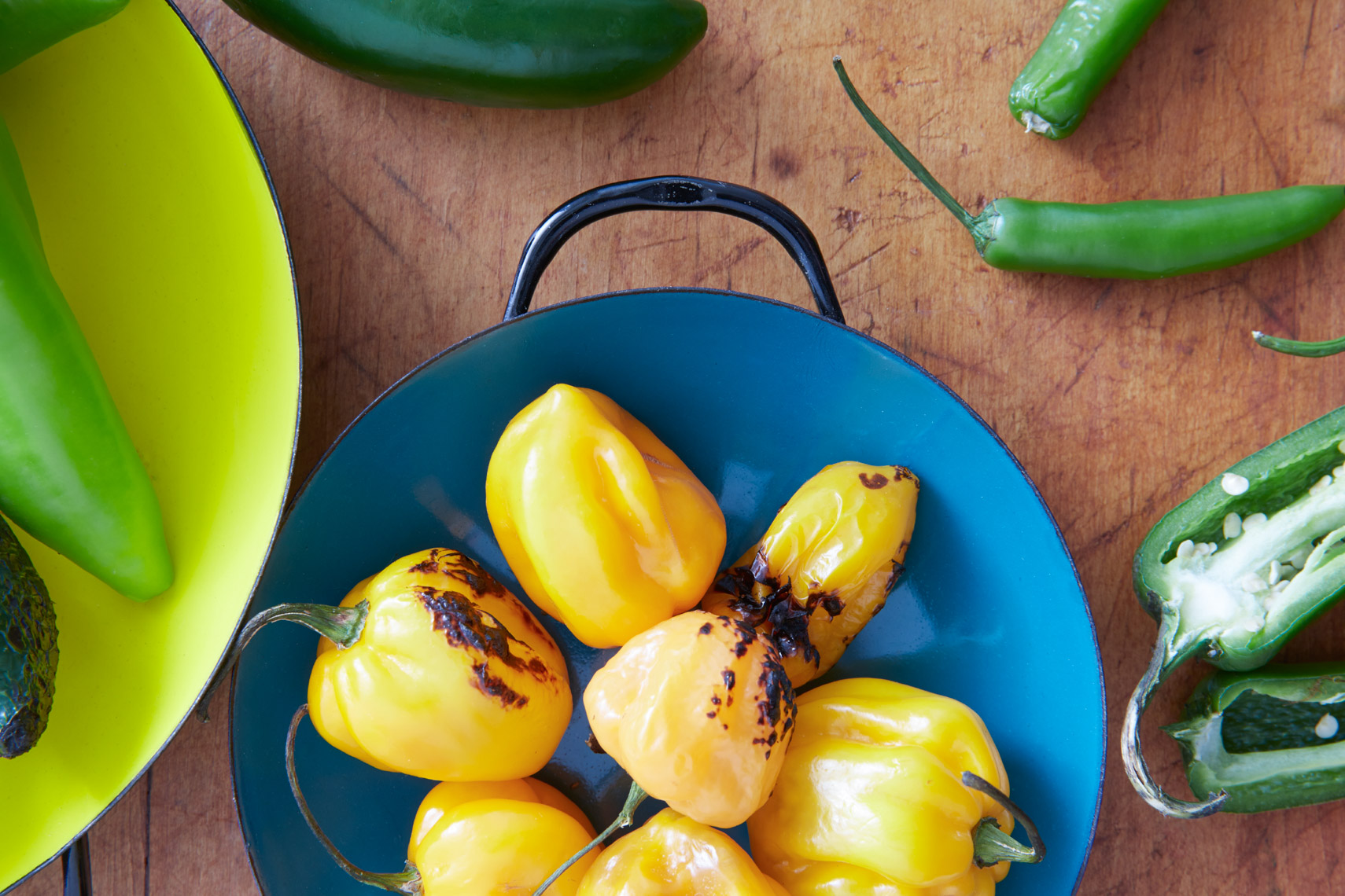 grilled yellow peppers in a blue bowl and green vegetables on wooden surface San Francisco food photographer