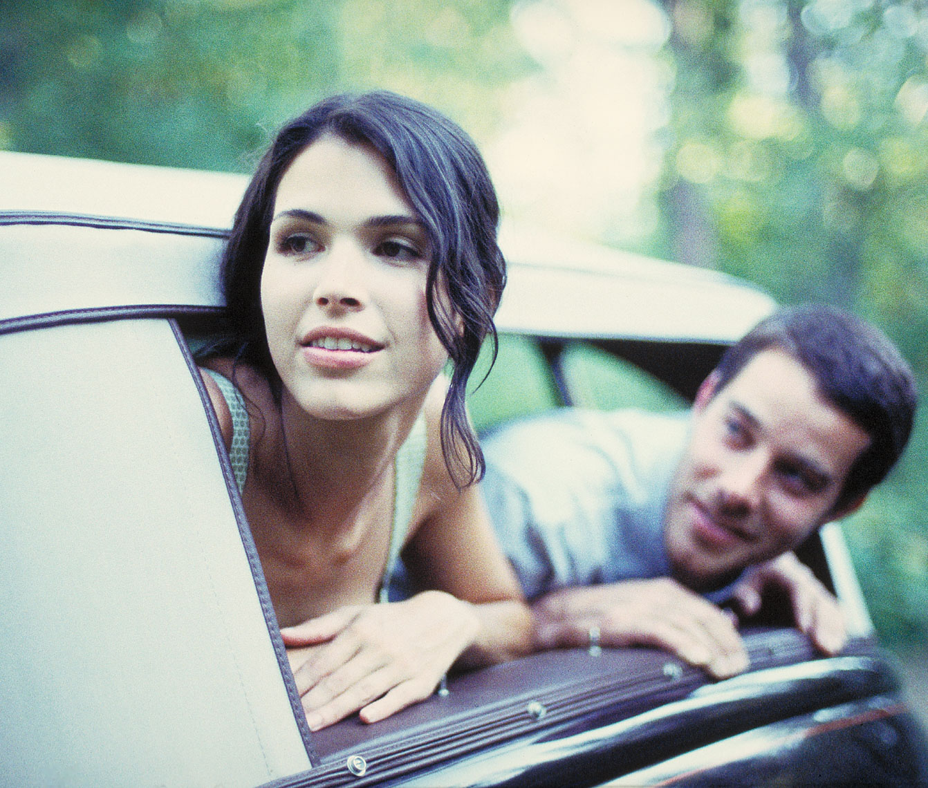 Woman and man leaning out of vintage car window in the forest San Francisco lifestyle photographer